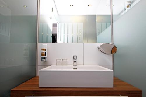 uma casa de banho com um lavatório branco e um espelho. em Pension am Kurpark em Viena