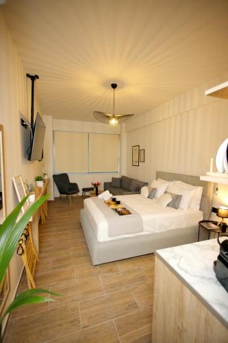 a bedroom with a large white bed and a couch at Blisséa in Piraeus