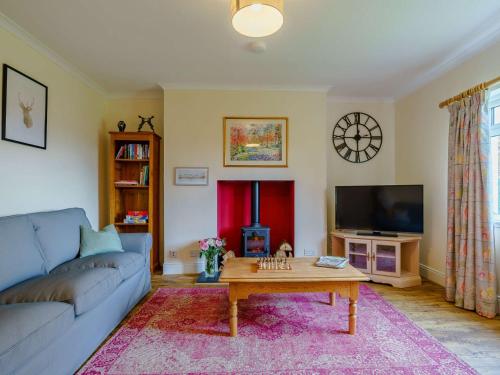 a living room with a blue couch and a coffee table at 3 Bed in Blairgowrie 90111 in Blairgowrie