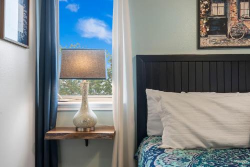 a bed with a lamp on a table next to a window at Retreat by Design - Resort Amenities in Branson West