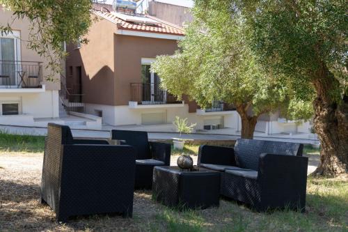 a group of chairs and tables in front of a building at Valery Apartments in Pefkohori