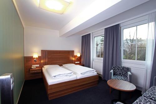 una camera d'albergo con letto e finestra di Pension am Kurpark a Vienna