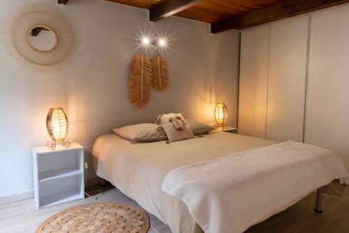 - une chambre avec un lit avec deux lampes et un tabouret dans l'établissement Palauma Plage, à Sari-Solenzara