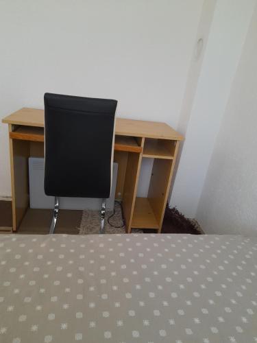 a desk with a chair in front of a desk with a computer at DM Apartman in Foča