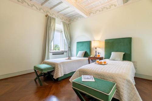 a hotel room with two beds and a window at Villa Loretino I Ultimate Luxury in Florence in Comeana