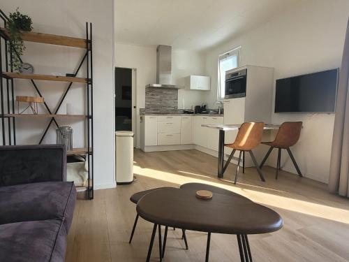 una sala de estar con un sofá y una mesa en Vakantiehuis Huisje 31 Zoutelande, en Zoutelande