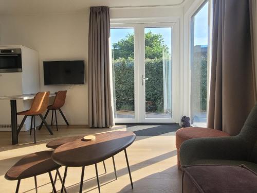 Una sala de estar con una mesa y una gran ventana. en Vakantiehuis Huisje 31 Zoutelande, en Zoutelande