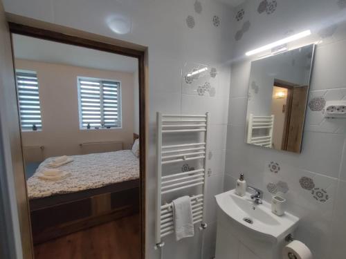 a white bathroom with a sink and a mirror at Take a Break in Braşov
