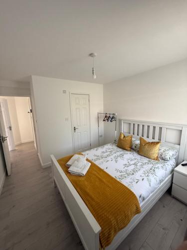 a white bedroom with a large bed with yellow pillows at Sleep In oxford in Oxford