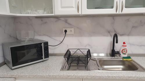 a kitchen counter with a sink and a microwave at Apartmán Strečno v centre s výhľadom na Lomnický štít in Vysoké Tatry
