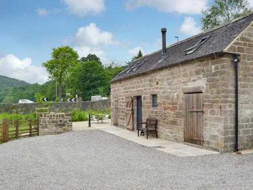 an old stone building with a wooden door at Fishermans Lodge in Highpeak Junction