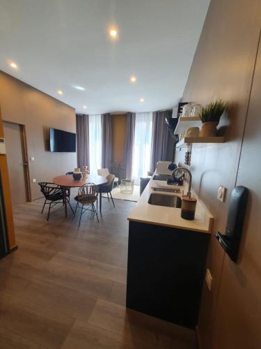 a kitchen and a living room with a table at Legend Majestic - Parking Privé GRATUIT- Climatisation - Gare - Centre Ville - FIBRE in Mâcon