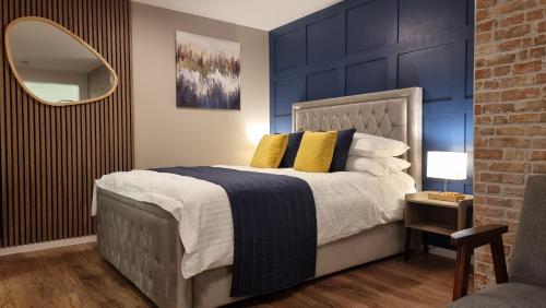 a bedroom with a large bed with a blue wall at Boxford Lodge - Serviced Apartment in Bracknell, near Ascot & Windsor, Free Parking in Bracknell