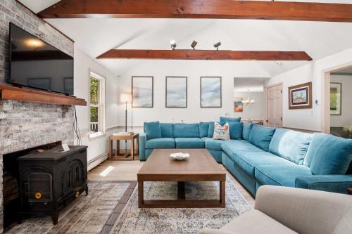 a living room with a blue couch and a fireplace at Classic Home close to Ponds Dog Welcome in Brewster