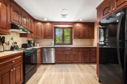 a kitchen with wooden cabinets and stainless steel appliances at Classic Home close to Ponds Dog Welcome in Brewster