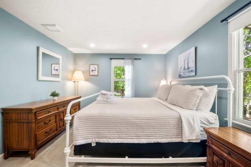 a bedroom with a bed and a desk and windows at Classic Home close to Ponds Dog Welcome in Brewster