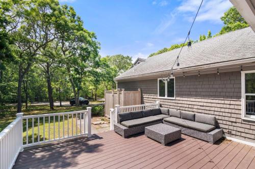 a patio with a couch on a wooden deck at Classic Home close to Ponds Dog Welcome in Brewster