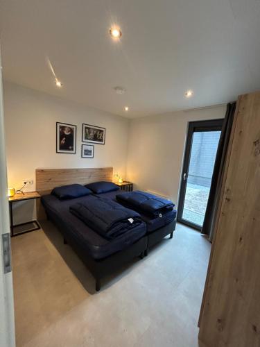 a bedroom with a large bed and a large window at Beach villa at the IJsselmeer 8p in Enkhuizen