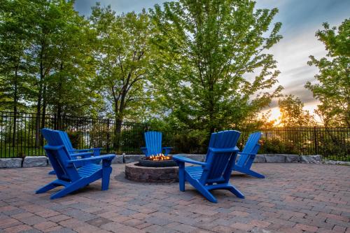 three blue chairs sitting around a fire pit at The Milkweed - 18 Meadow View in Cherry Valley