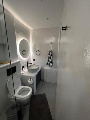 a white bathroom with a toilet and a sink at The wave in Kardiani