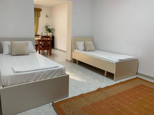 een slaapkamer met 2 bedden en een eetkamer bij Cosyy House in Vlorë