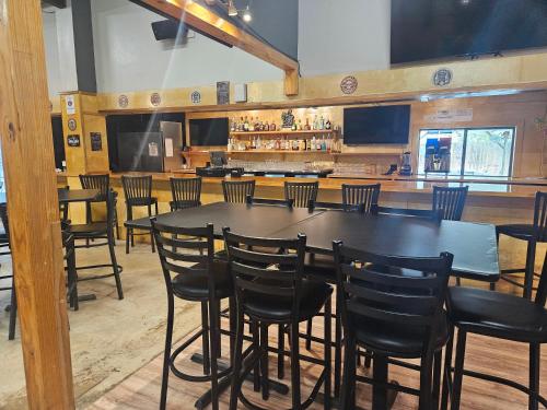 a dining room with a table and chairs and a bar at El Dorado Suites in Crystal City