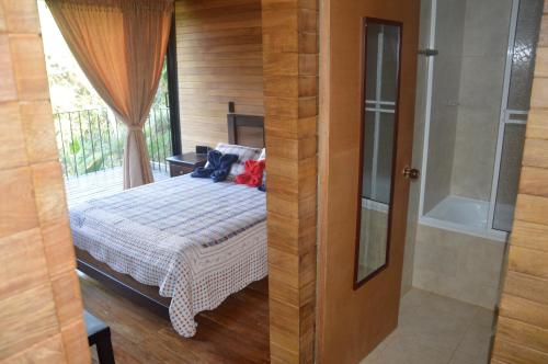 a bedroom with a bed and a glass door at Cabañas el Retorno in Guatapé