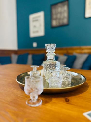 a tray with bottles and glasses on a table at Λαμπρινής Guest House-Zagori in Asprangeloi