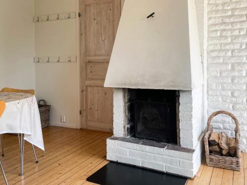 a living room with a brick fireplace with a table at 4 person holiday home in H viksn s in Höviksnäs