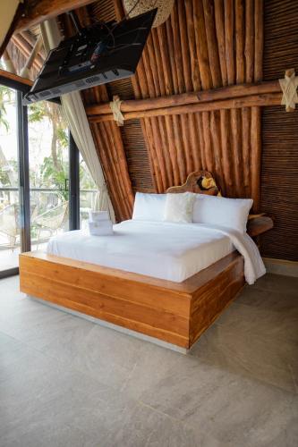 Un dormitorio con una cama grande con sábanas blancas. en Marbelha Safari Beach, en Coveñas