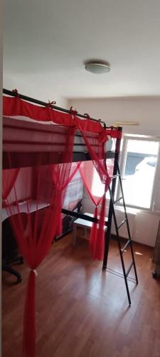 ein Etagenbett mit roten Vorhängen und einer Leiter in der Unterkunft logement calme in Saint-Nazaire