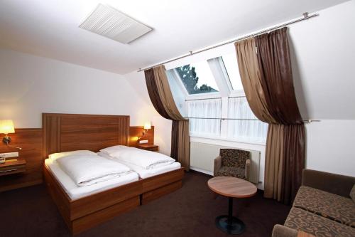 a bedroom with a bed and a window at Pension am Kurpark in Vienna