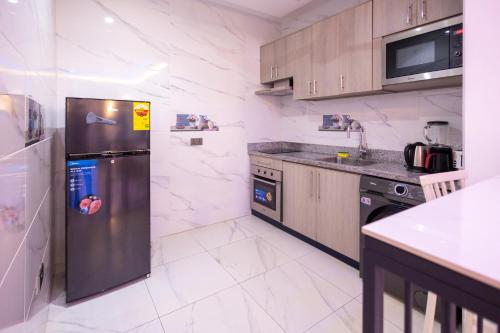 a kitchen with a stainless steel refrigerator and appliances at Executive Studio Apartment, East Airport in Accra