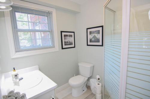 a white bathroom with a toilet and a sink at The Jypsy Inn - Tuxedo Room Muskoka in Bracebridge