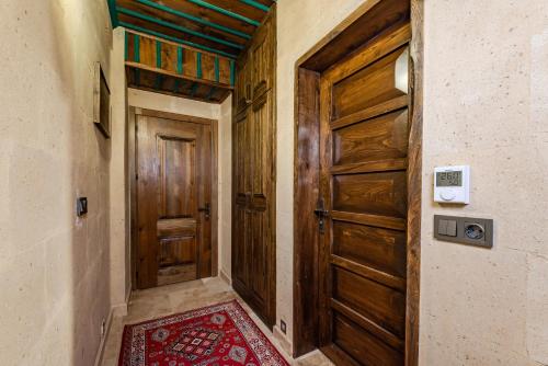 a hallway with a wooden door and a red rug at Soho Cappadocia in Goreme
