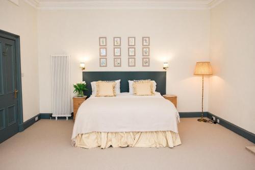 a bedroom with a large white bed with two pillows at Torr House Hotel in Dumfries