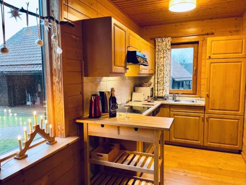 a kitchen with a table in a wooden cabin at Ferienhaus Blauvogel 4 in Hasselfelde