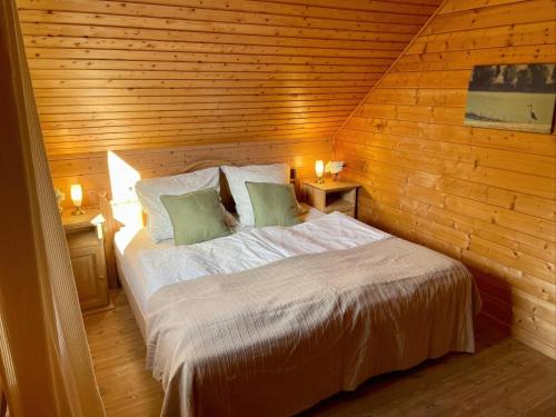 a bedroom with a bed in a wooden wall at Ferienhaus Blauvogel 4 in Hasselfelde
