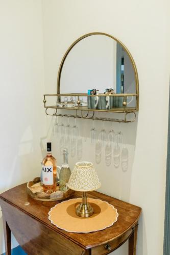 a table with a mirror and a lamp on it at Torr House Hotel in Dumfries
