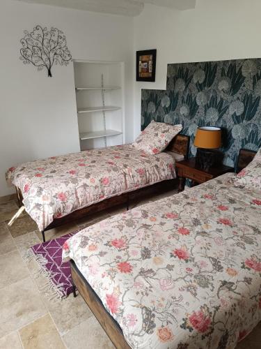 - 2 lits dans une chambre avec papier peint floral dans l'établissement Les jardins de Shambhala, à Montrem