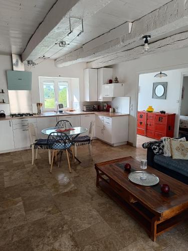 Il dispose d'une cuisine et d'un salon avec une table et un canapé. dans l'établissement Les jardins de Shambhala, à Montrem