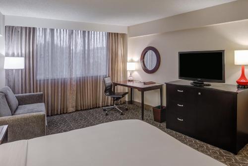 a hotel room with a bed and a desk with a television at The Brookhaven Atlanta Hotel in Atlanta