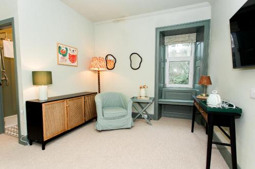 a room with a desk and a chair and a table at Torr House Hotel in Dumfries