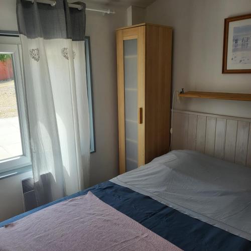 a small bedroom with a bed and a window at Le Mas de la Palmeraie - Studio dans propriété privée au calme avec piscine et tennis in Bormes-les-Mimosas