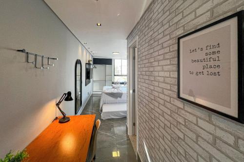 a room with a brick wall and a table with a lamp at Studio Luxo 150m Praia Intermares 3 Pessoas in Ilha da Restinga