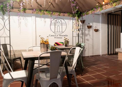 a dining area with tables and chairs and a sign that reads cass la maria at Casa La Morada in Medellín