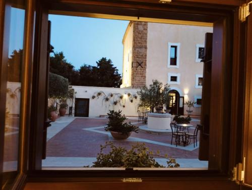 a view of a courtyard from a window at Hotel Foresteria Baglio Della Luna in San Leone