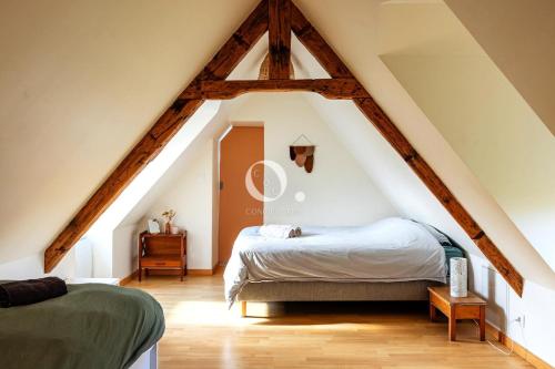 a attic room with two beds and a window at COC - Villa La Finca in Audembert
