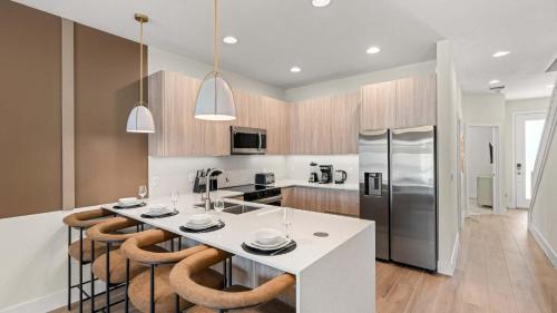 a kitchen with a large white island with bar stools at Upstay Pristine 3BR Home with Private Pool & BBQ in Orlando