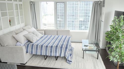 a living room with a couch with a striped blanket at Pantages Skyline Suite in Toronto Centre - Free Parking in Toronto